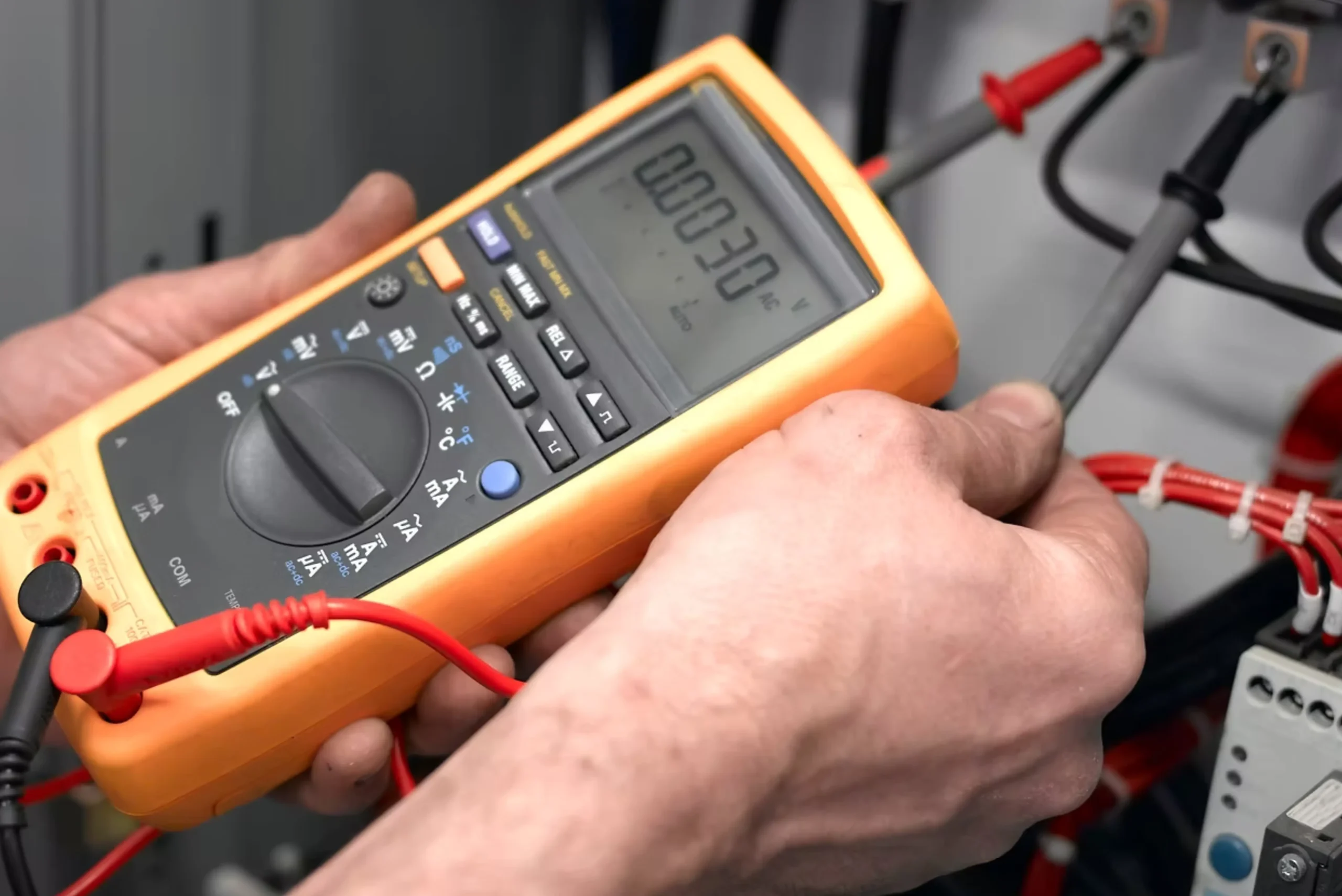 Electrician using a digital multimeter to test electrical wiring