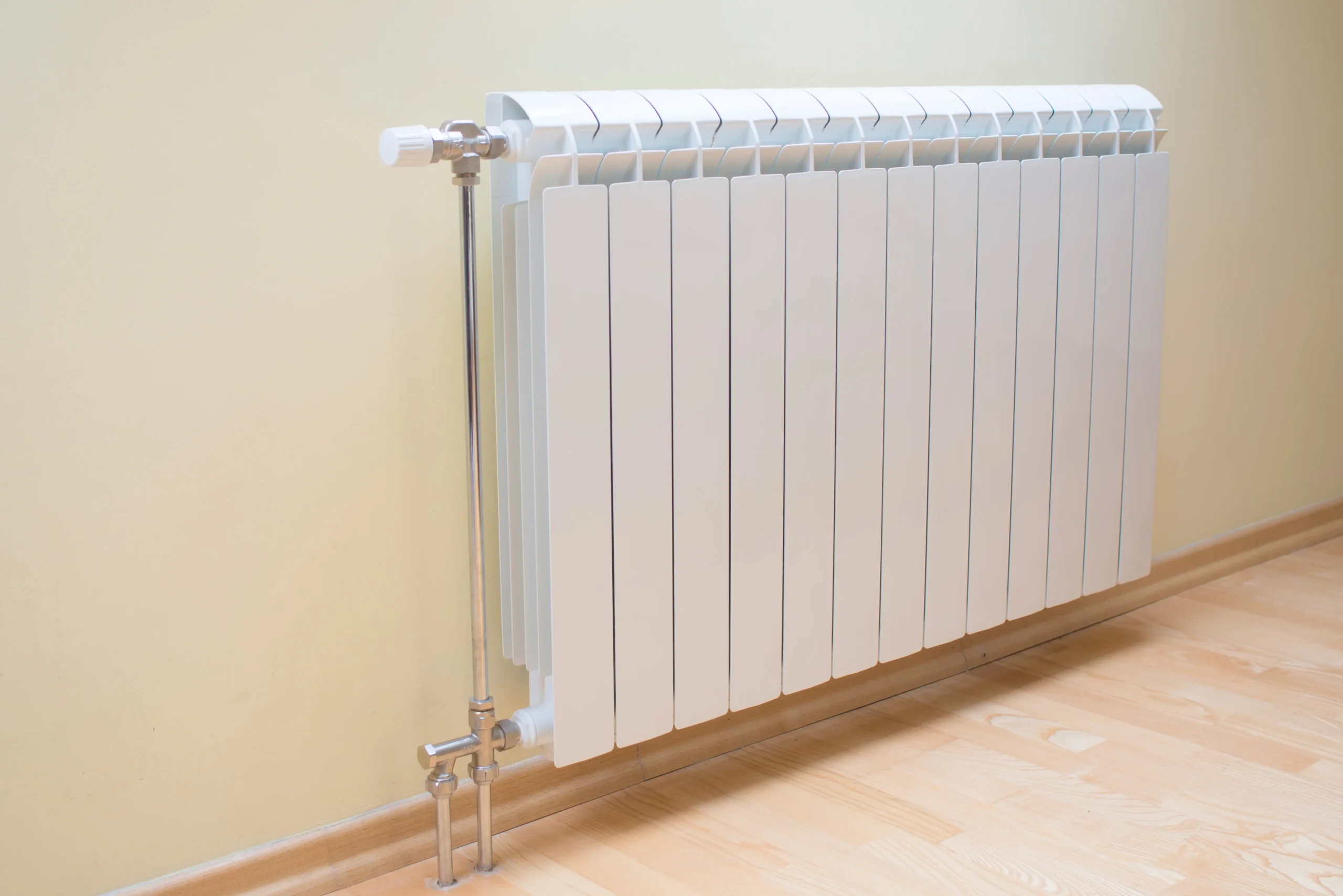 Wall-mounted white electric radiator in a home