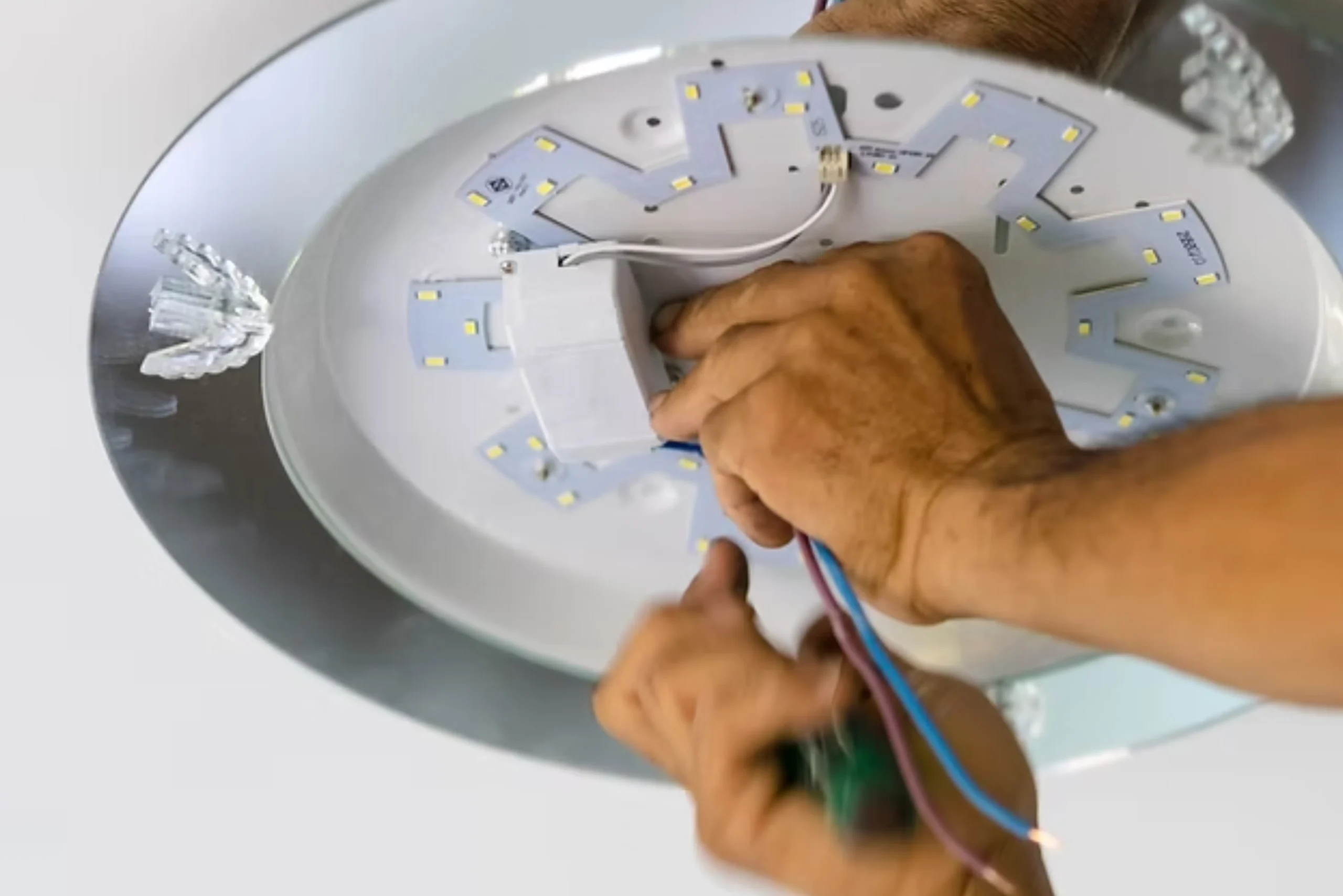 Electrician wiring a new LED ceiling light fitting